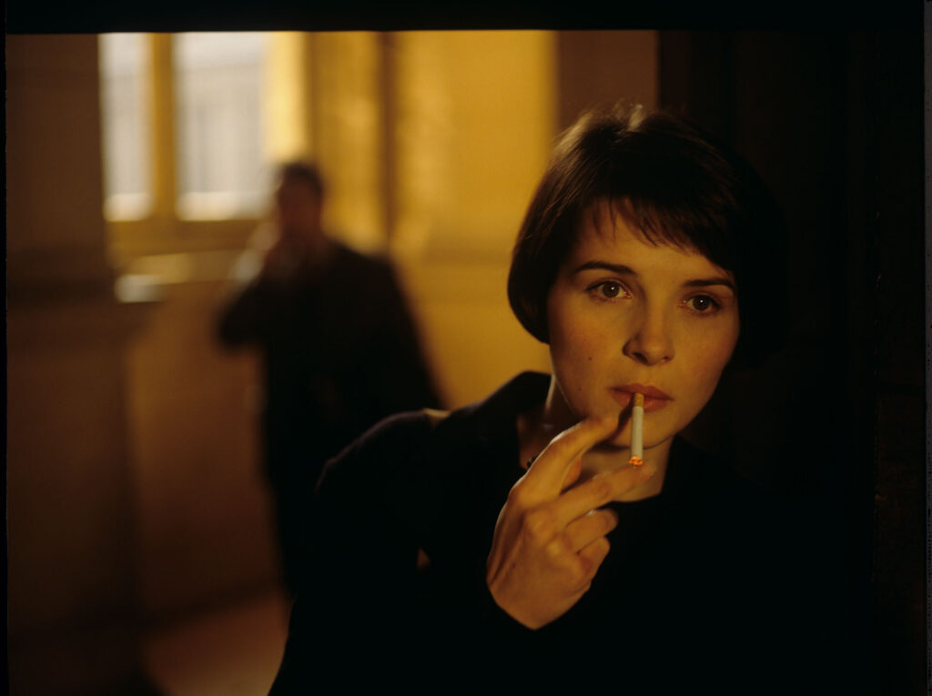 Julie (Juliette Binoche) lights a cigarette in the hall of the Palace of Justice in Paris.