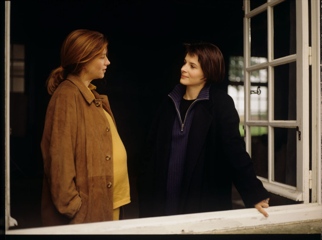 Sandrine (Florence Pernel) and Julie (Juliette Binoche) at the window of the de Courcy family residence near Paris.