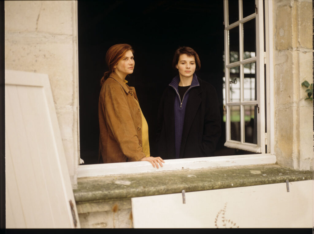 Sandrine (Florence Pernel) and Julie (Juliette Binoche) at the window of the de Courcy family residence near Paris.