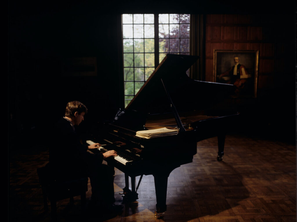Olivier (Benoit Regent) at the piano in Patrice de Courcy's office at the music conservatory.