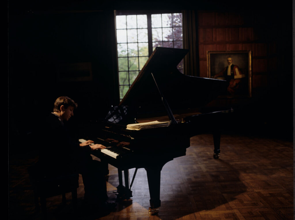 Olivier (Benoit Regent) at the piano in Patrice de Courcy's office at the music conservatory.