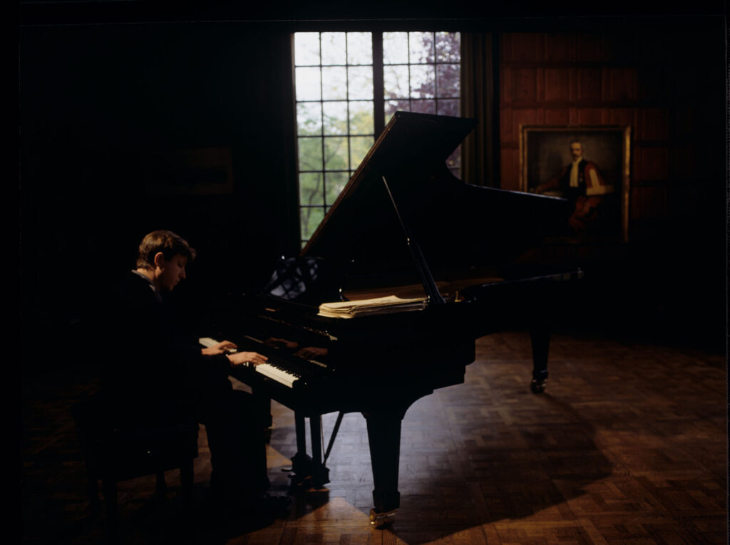Olivier (Benoit Regent) at the piano in Patrice de Courcy's office at the music conservatory.