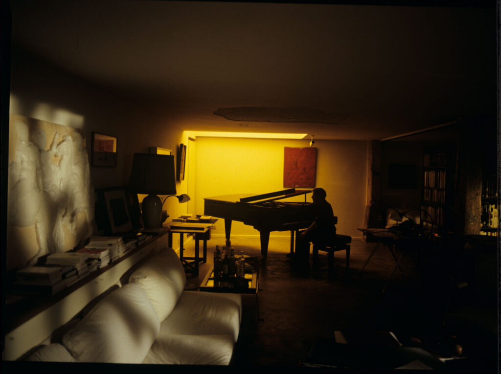 Olivier (Benoit Regent) is working at the piano in his apartment on completing Patrice de Courcy's oratorio.