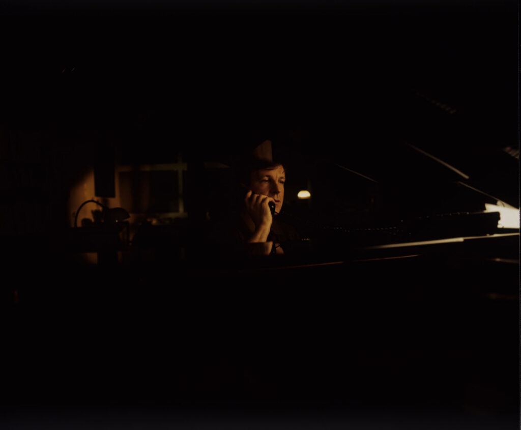 Olivier (Benoit Regent) at the piano in his apartment while talking to Julie on the phone.