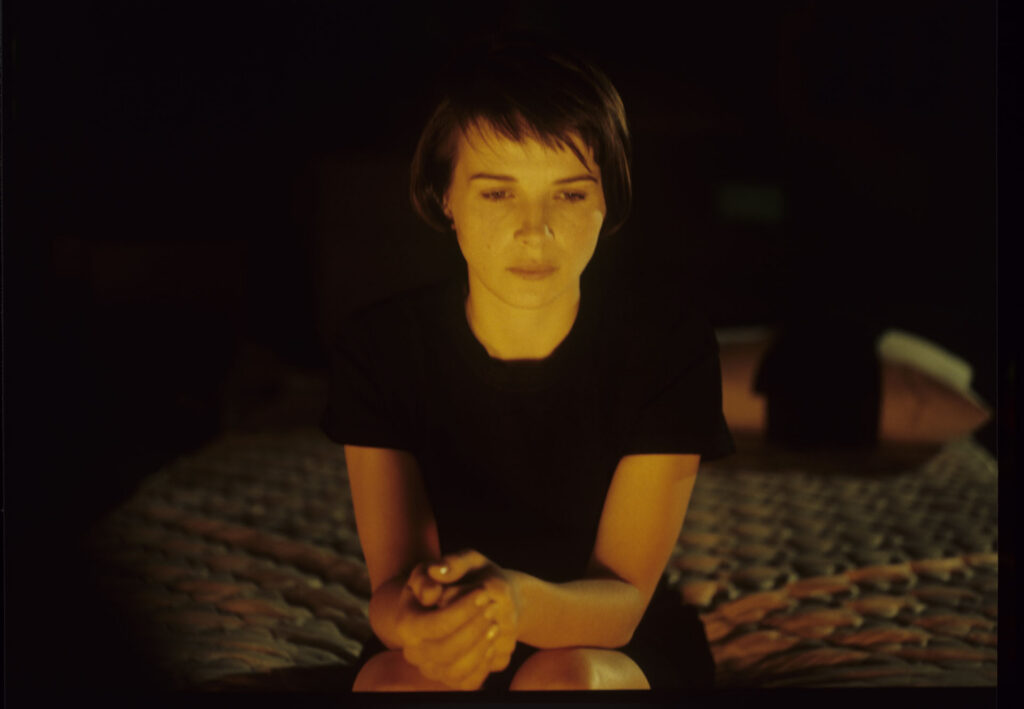 Julie (Juliette Binoche) in front of the fireplace in her home located near Paris