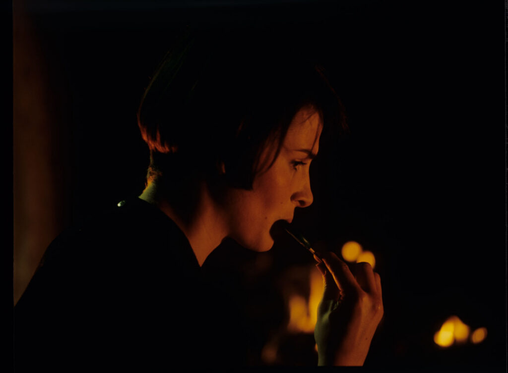 Julie (Juliette Binoche) in front of the fireplace in her home located near Paris
