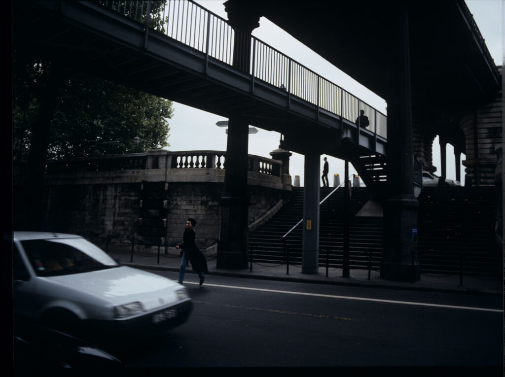Julie (Juliette Binoche) is running on the street to catch Olivier's departing car.