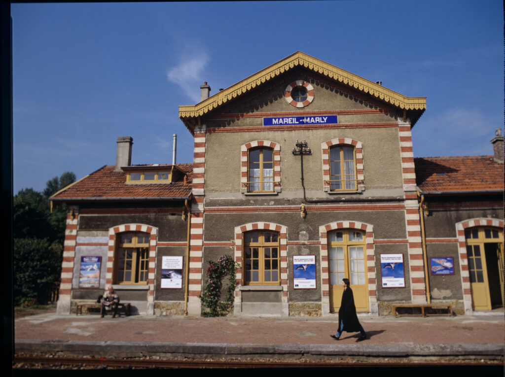 A railway station in a town near Paris, where the de Courcy family estate is located.