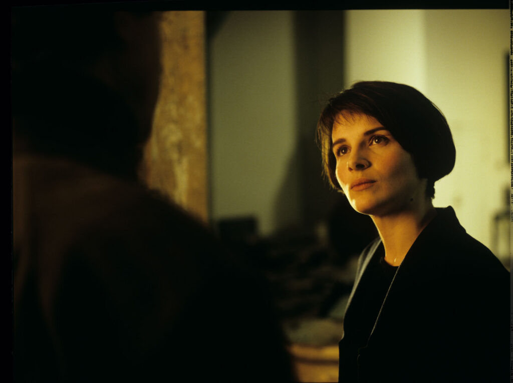 Julie (Juliette Binoche) talks to Olivier (Benoit Regent) in her Parisian residence.