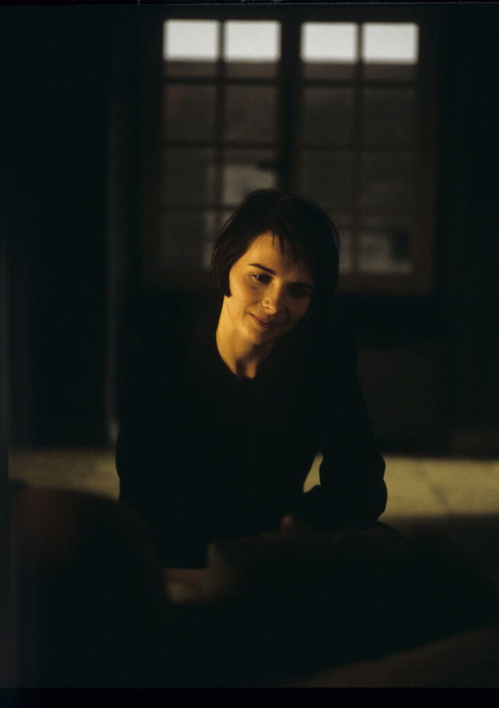 Julie (Juliette Binoche) watches Olivier (Benoit Regent) sleep after spending the night with him.