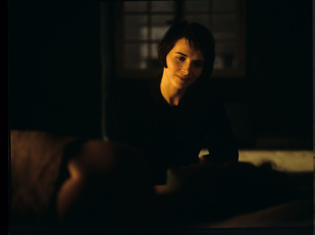 Julie (Juliette Binoche) watches Olivier (Benoit Regent) sleep after spending the night with him.