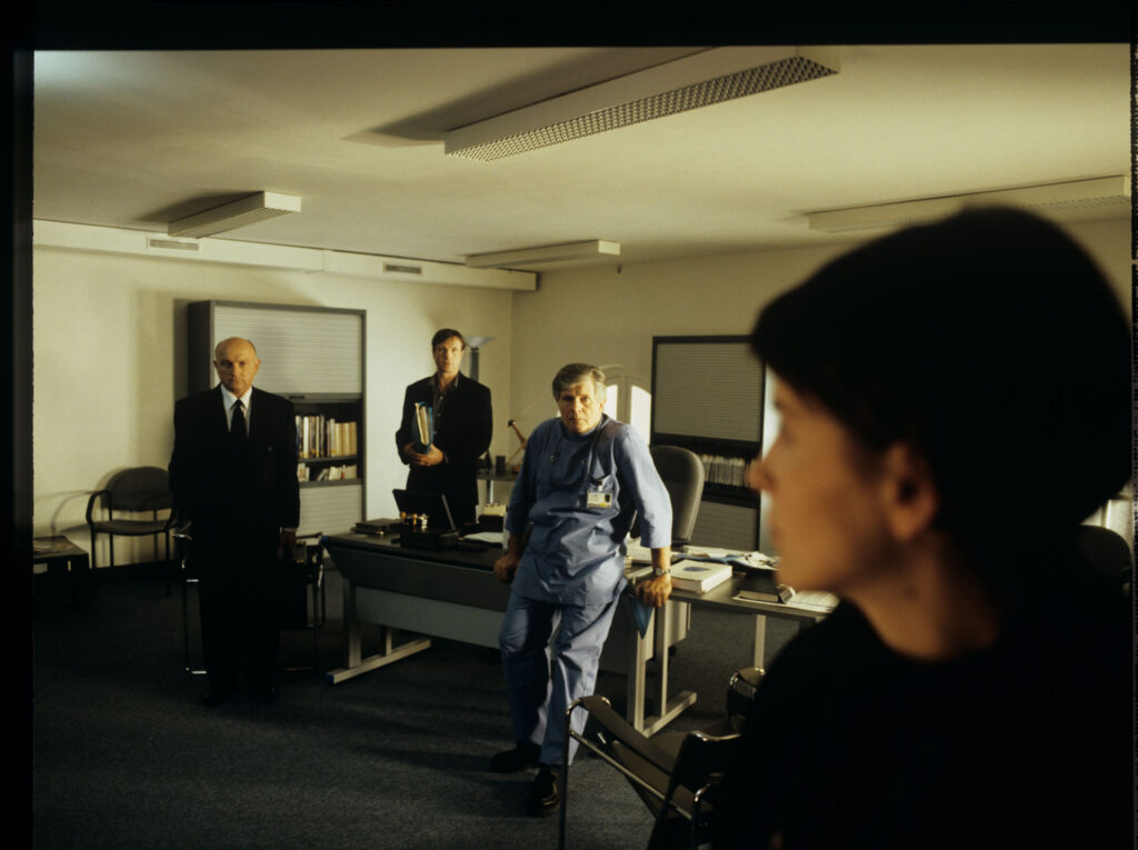 Julie (Juliette Binoche) during a check-up visit to the doctor (Claude Duneton).
