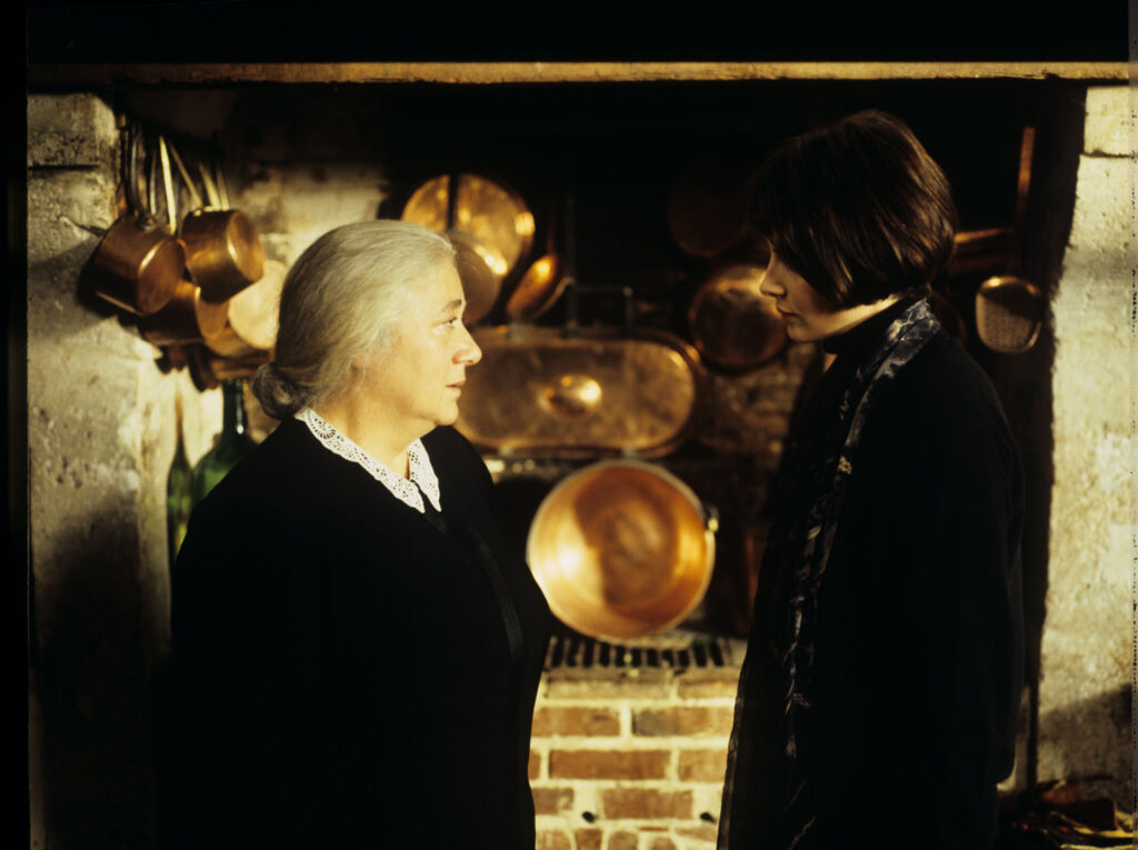 Julie (Juliette Binoche), after leaving the hospital, talks to a maid (Isabelle Sadoyan) in the kitchen of her mansion.