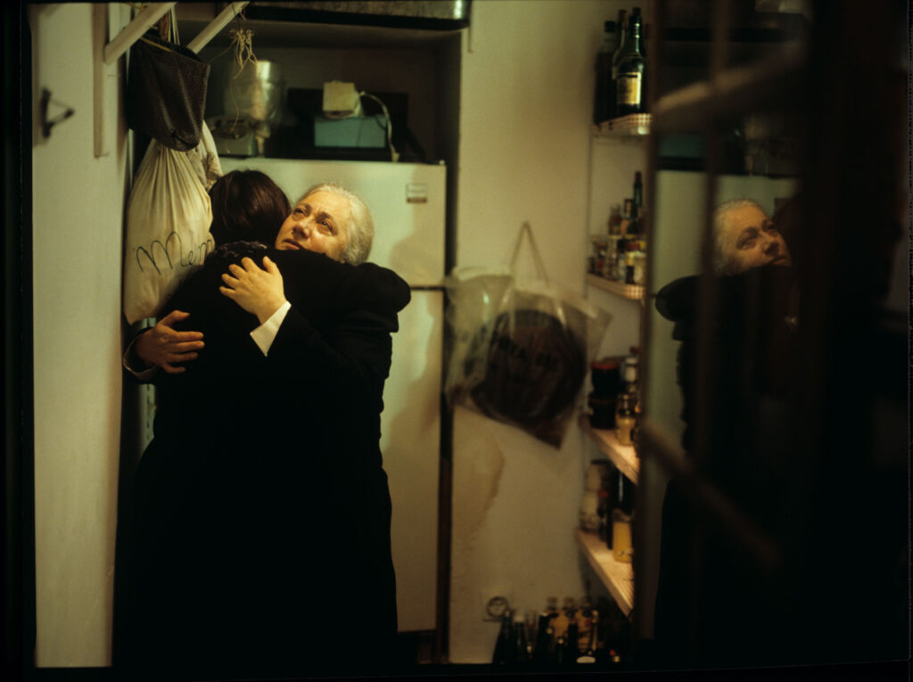 Julie (Juliette Binoche), after leaving the hospital, talks to a maid (Isabelle Sadoyan) in the kitchen of her mansion.
