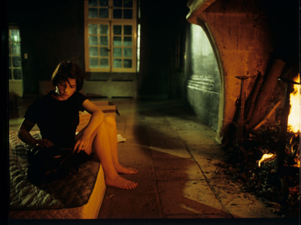 Julie (Juliette Binoche) in front of the fireplace in her big house, which was emptied and only the mattress remained.