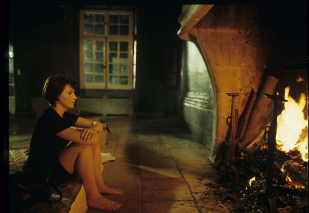 Julie (Juliette Binoche) in front of the fireplace in her big house, which was emptied and only the mattress remained.