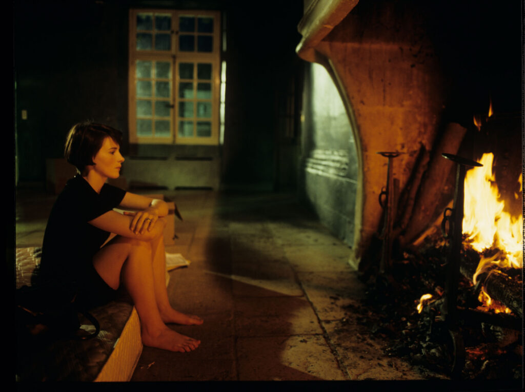 Julie (Juliette Binoche) in front of the fireplace in her big house, which was emptied and only the mattress remained.