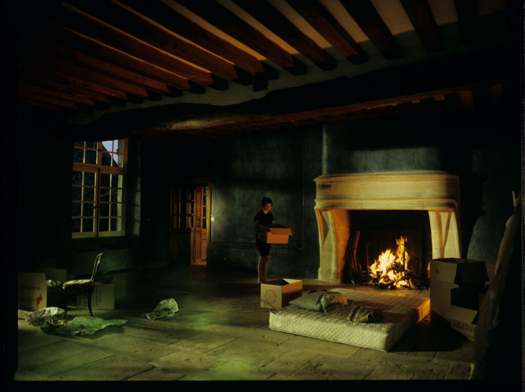 Julie (Juliette Binoche) in front of the fireplace in her big house, which was emptied and only the mattress remained.