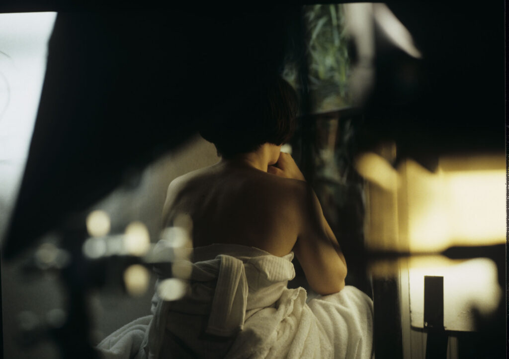 Julie (Juliette Binoche) in front of the fireplace in her big house, which was emptied and only the mattress remained.