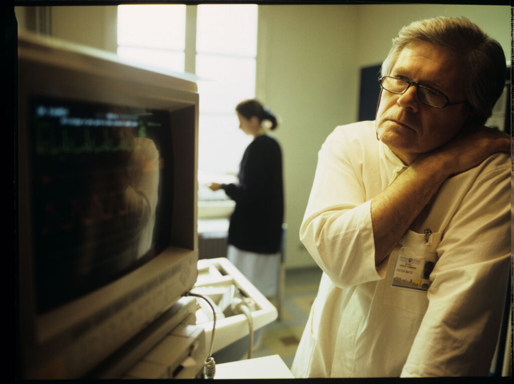 A doctor (Claude Duneton) monitors a patient's vital signs in the hospital's intensive care unit.