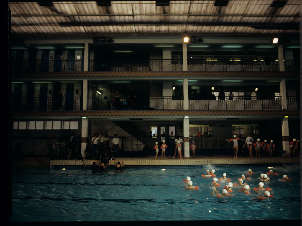 Grupa dzieci na basenie Piscine Pontoise w Paryżu, gdzie Julie, główna bohaterka filmu, systematycznie pływa.