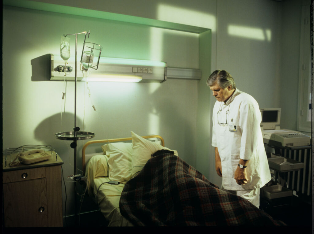 Doctor (Claude Duneton) informs Julie (Juliette Binoche) about the death of her husband and daughter.