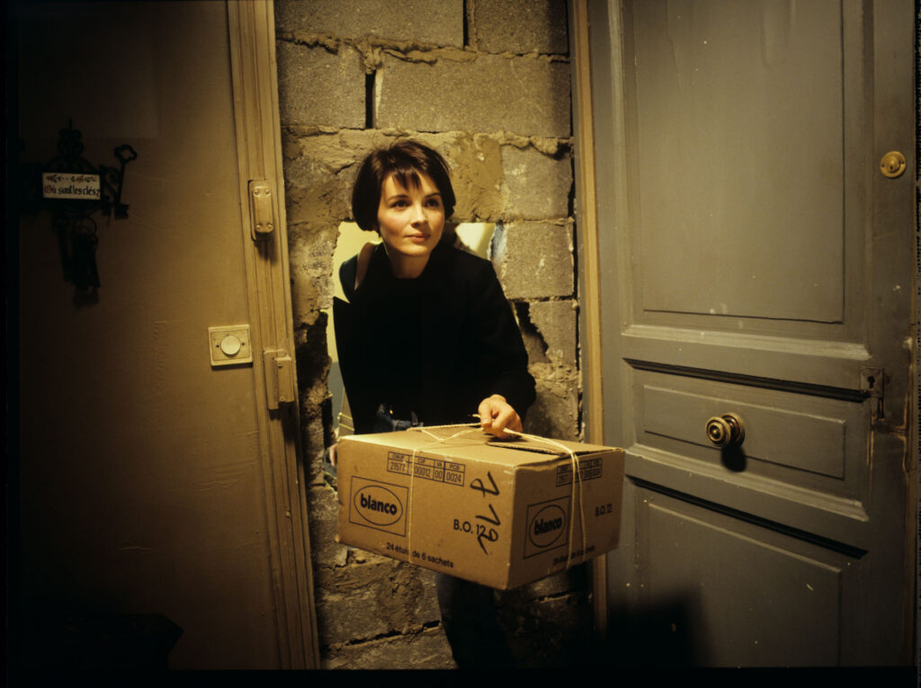 Julie (Juliette Binoche) enters her new apartment with a package with a blue chandelier.