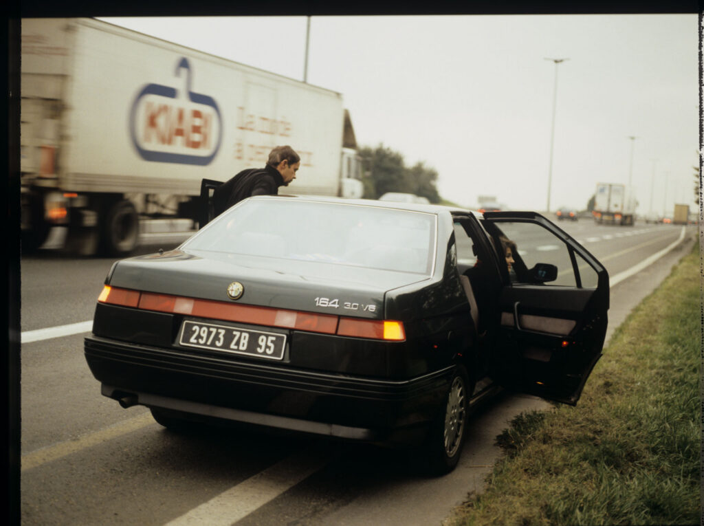 Patrice de Courcy (Hugues Quester), Julie's husband, and Julie (Juliette Binoche) on a motorway.