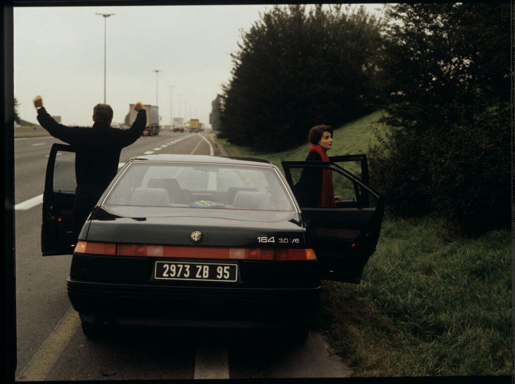 Patrice de Courcy (Hugues Quester), Julie's husband, and Julie (Juliette Binoche) on a motorway.