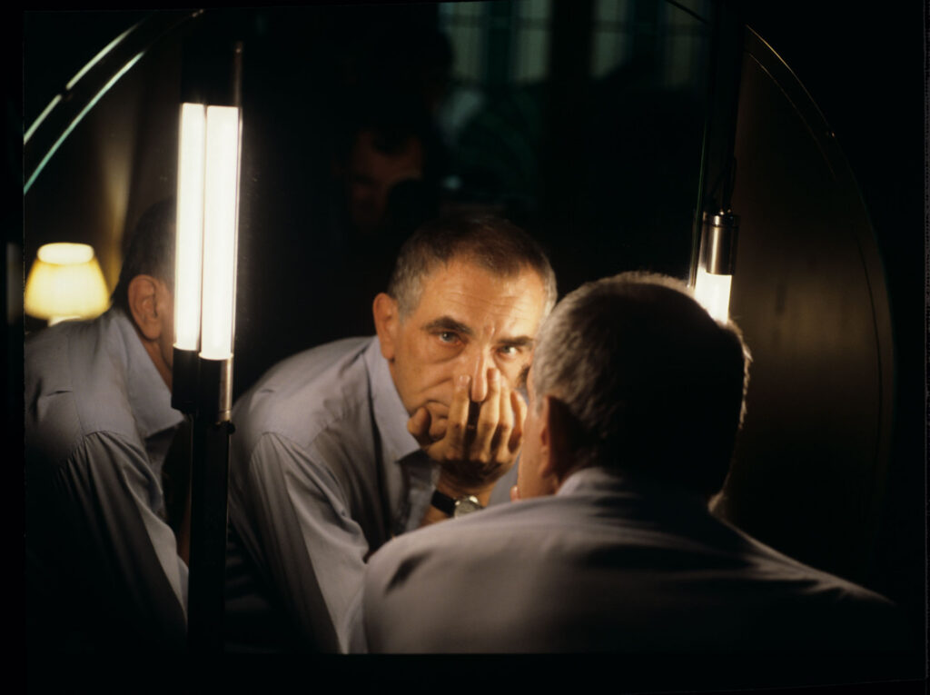 Krzysztof Kieślowski (reżyser) ogląda swoje odbicie w lustrze.