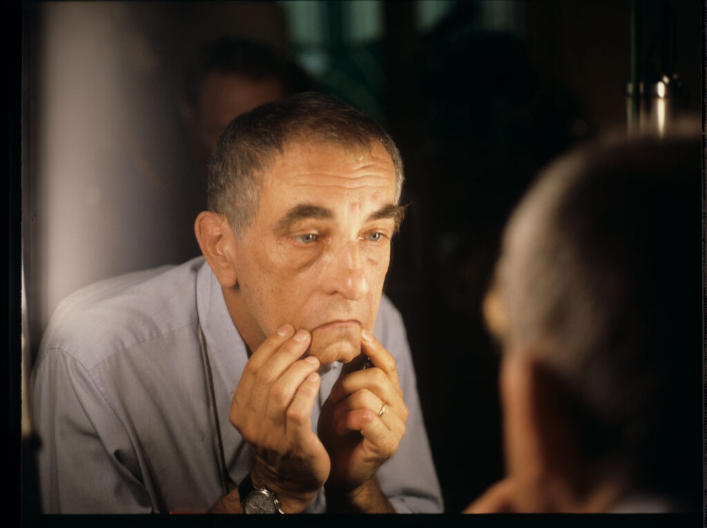 Krzysztof Kieślowski (reżyser) ogląda swoje odbicie w lustrze.