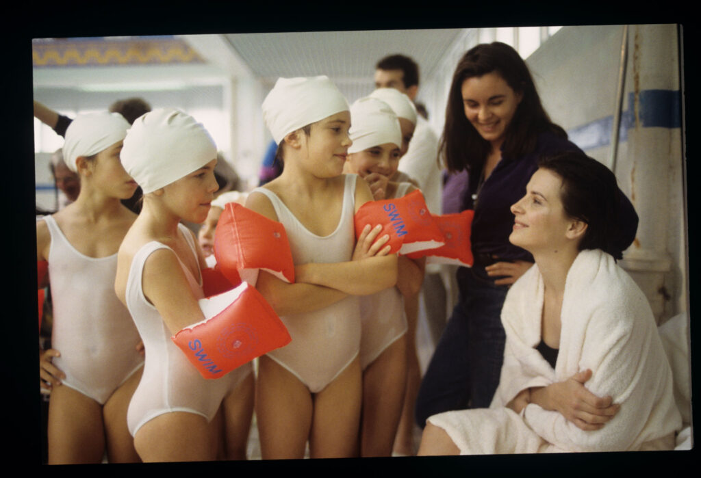 Juliette Binoche (odtwórczyni roli Julie) w otoczeniu dziewczynek z sekcji pływackiej, po zakończeniu zdjęć na basenie.