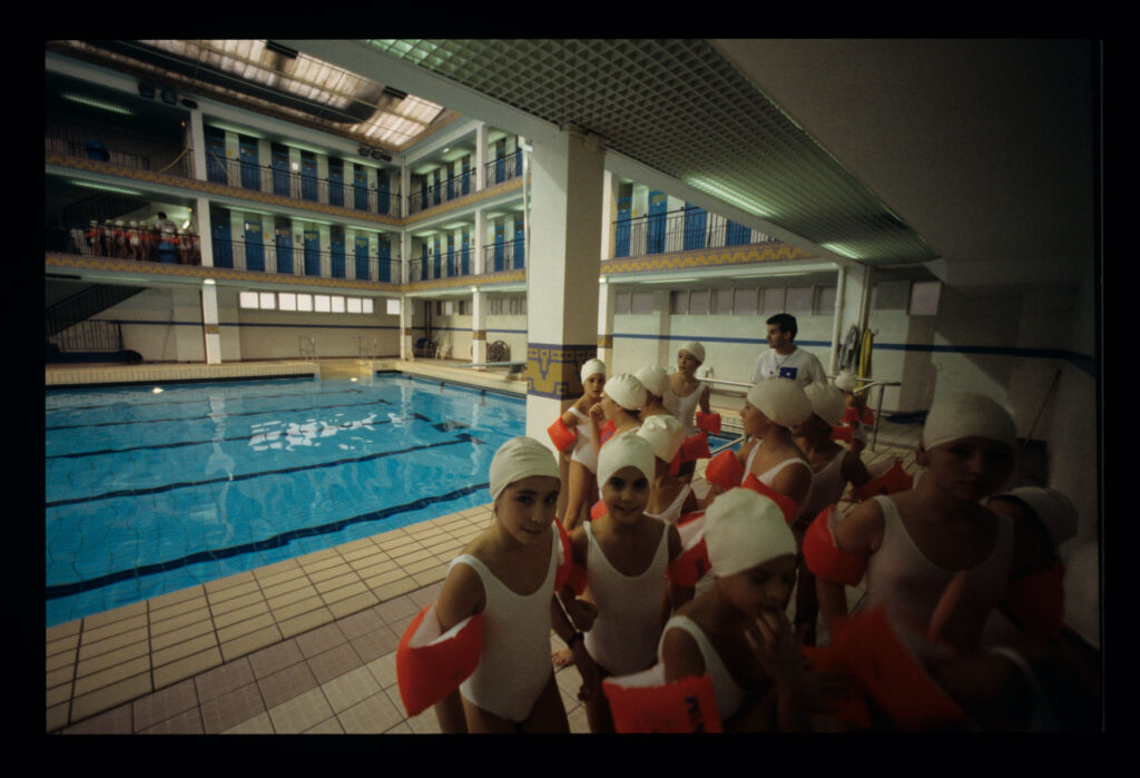 Grupa dziewczynek z sekcji pływackiej na basenie Piscine Pontoise w Paryżu.
