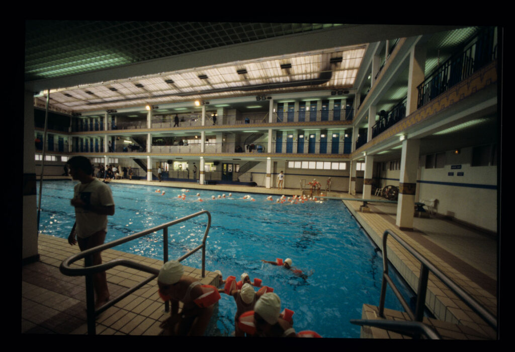 Grupa dzieci na basenie Piscine Pontoise w Paryżu.