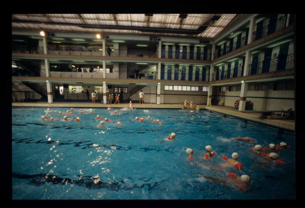 Grupa dzieci na basenie Piscine Pontoise w Paryżu.