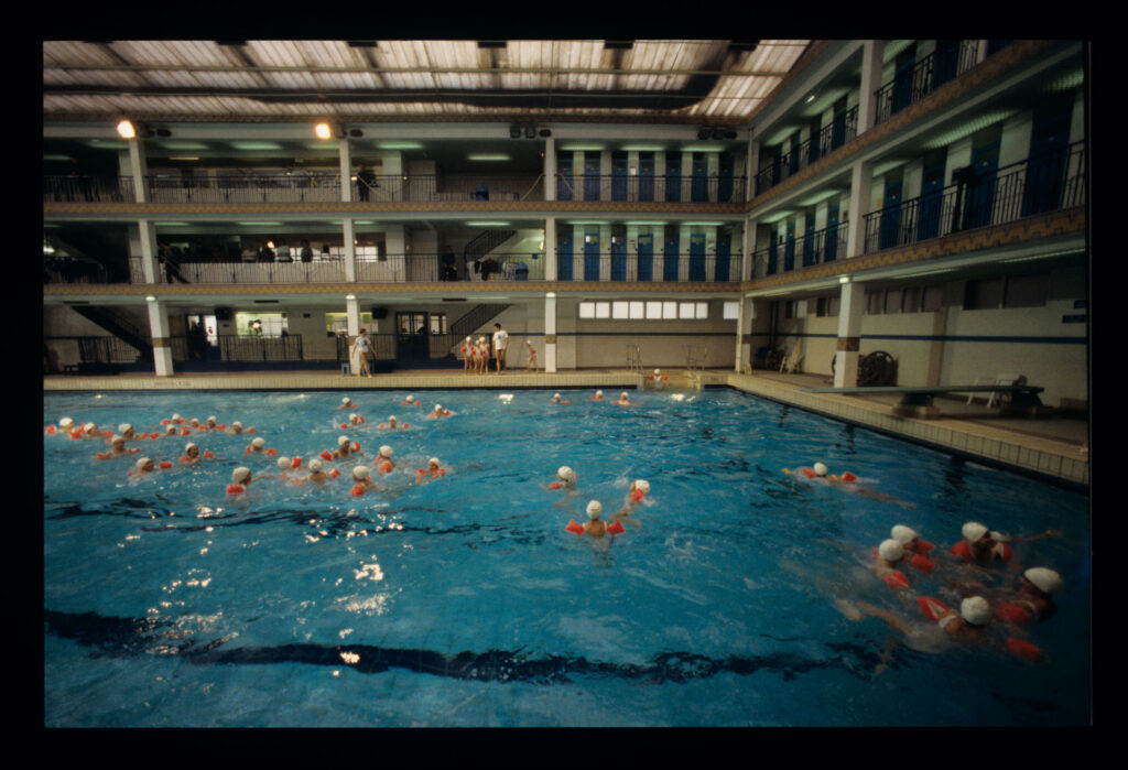 Grupa dzieci na basenie Piscine Pontoise w Paryżu.