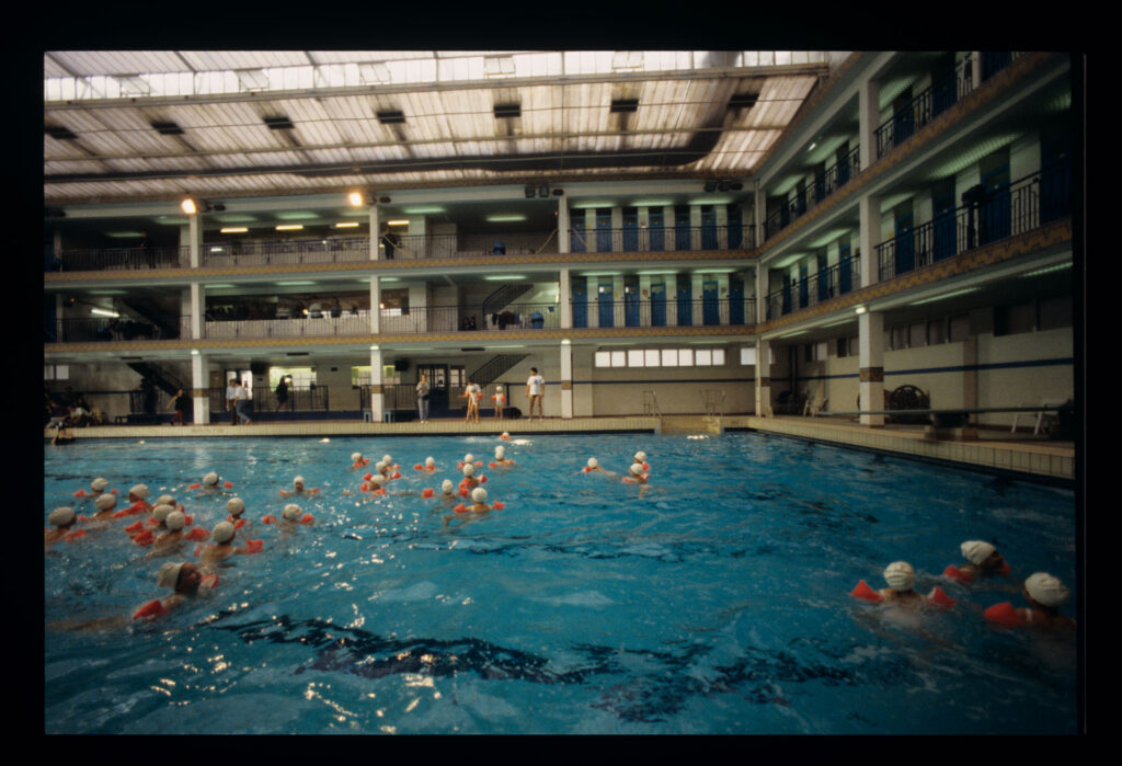 Grupa dzieci na basenie Piscine Pontoise w Paryżu.