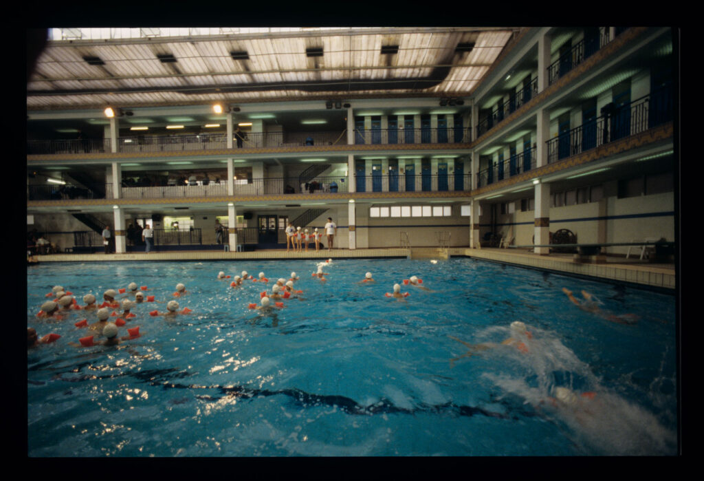 Grupa dzieci na basenie Piscine Pontoise w Paryżu.