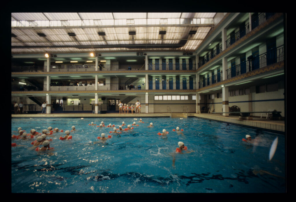 Grupa dzieci na basenie Piscine Pontoise w Paryżu.