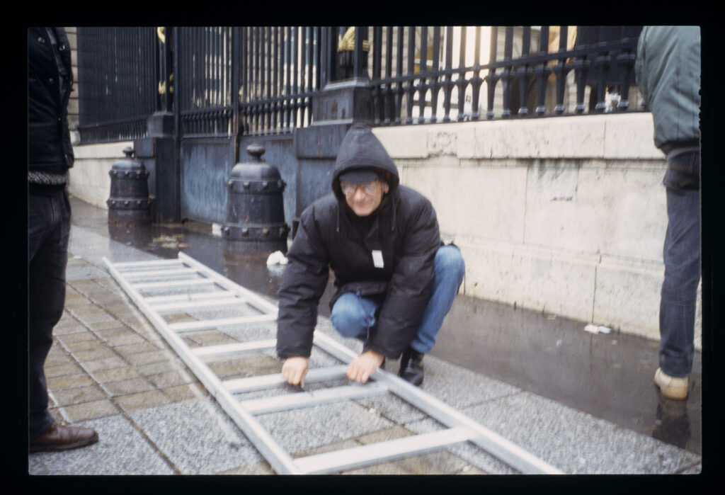 Krzysztof Kieślowski (director) with a ladder while preparing for the scene in front of the courthouse