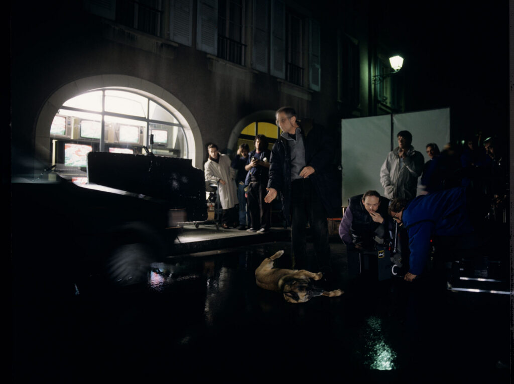 The film crew on the set prepares Rita the dog for the scene where the dog is hit by Valentine's car.