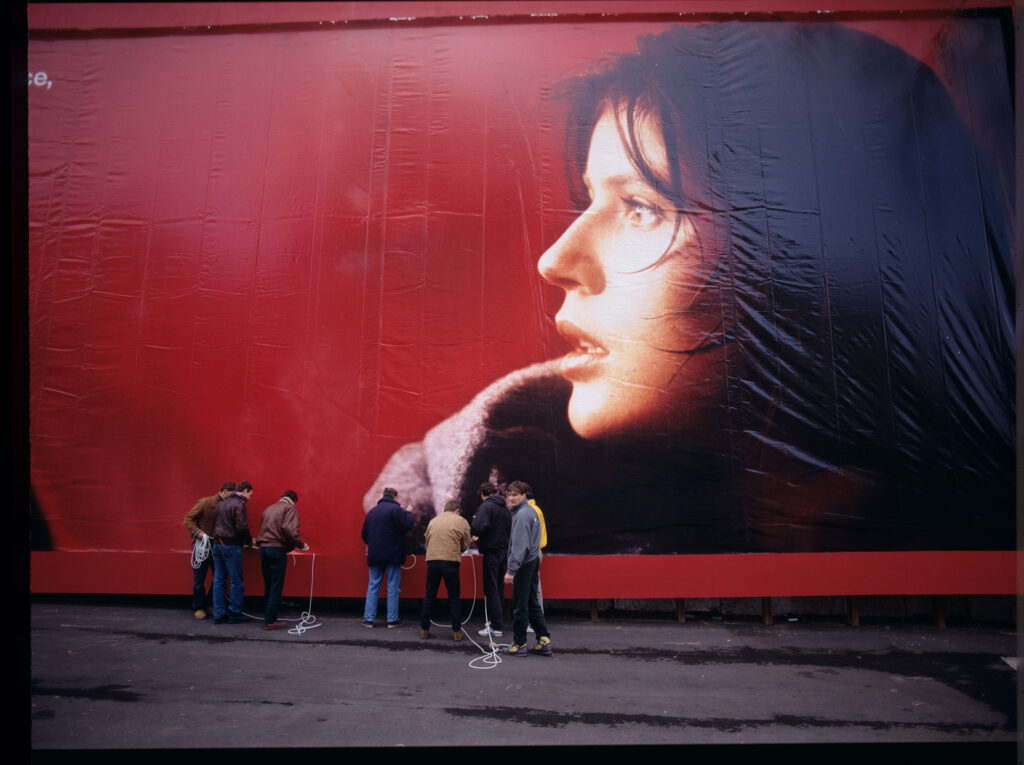 Ekipa filmowa podczas montażu billboardu reklamowego z podobizną Valentine - głównej bohaterki filmu.