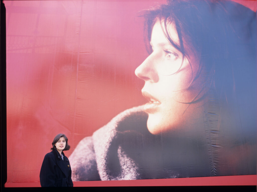 Irène Jacob na tle billboardu reklamowego z podobizną swojej filmowej bohaterki.