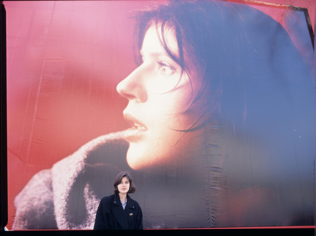 Irène Jacob na tle billboardu reklamowego z podobizną swojej filmowej bohaterki.